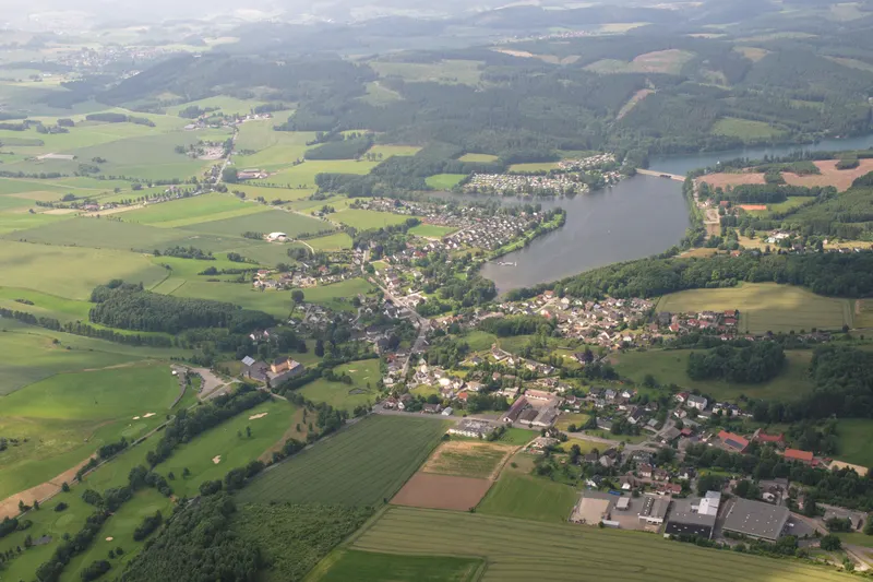 Jezioro Sorpesee z lotu ptaka, ze wsią Amecke na jego wschodnim brzegu i otaczającymi je zalesionymi wzgórzami Sauerlandu