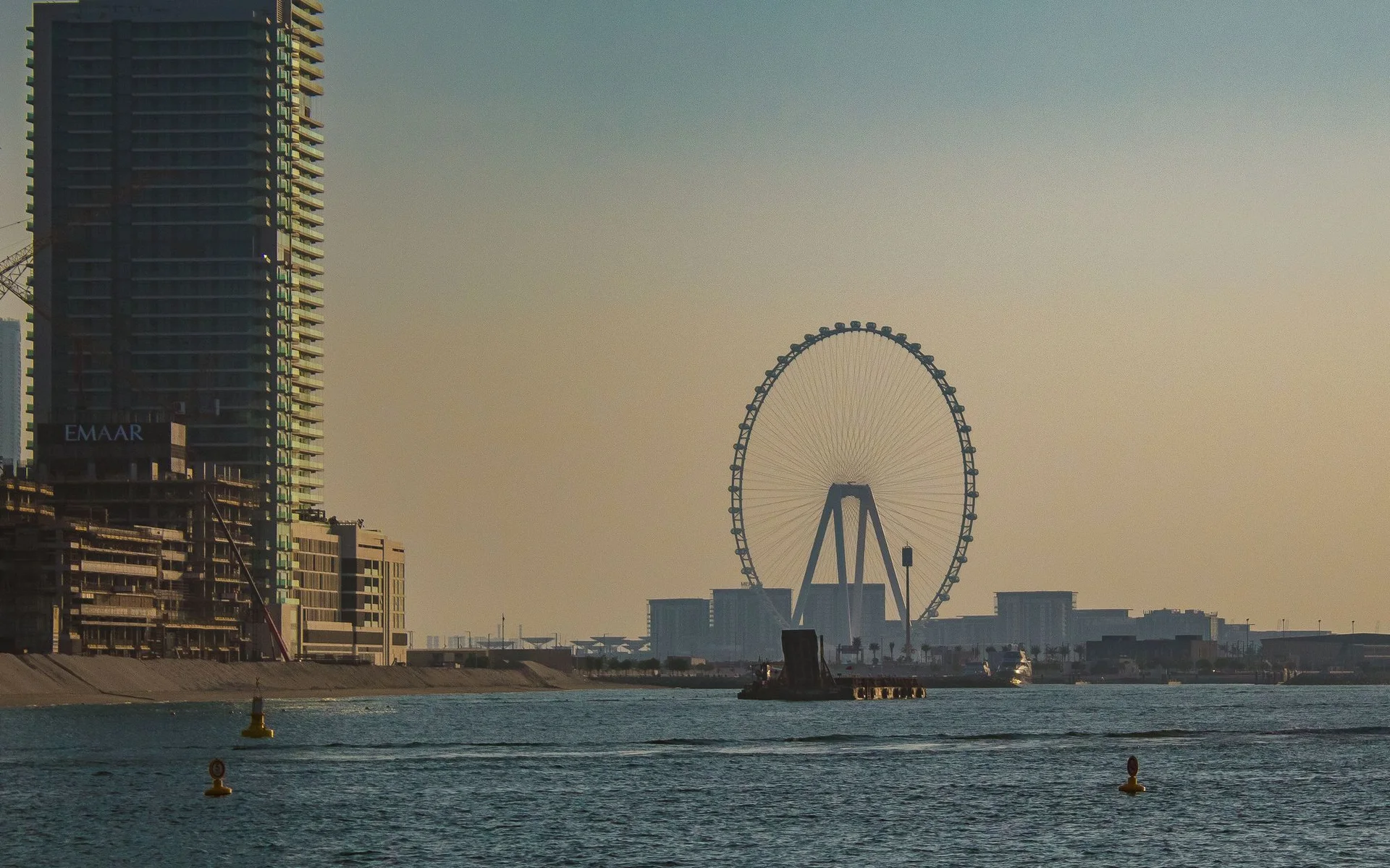 Panorama Dubaju z diabelskim młynem o zachodzie słońca