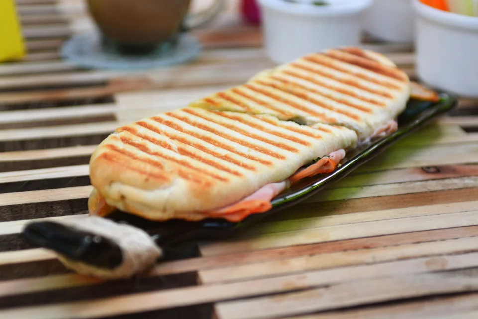 Przykładowe zdjęcie: Opieczony panini z śladami grillowania na ciemnym talerzu
